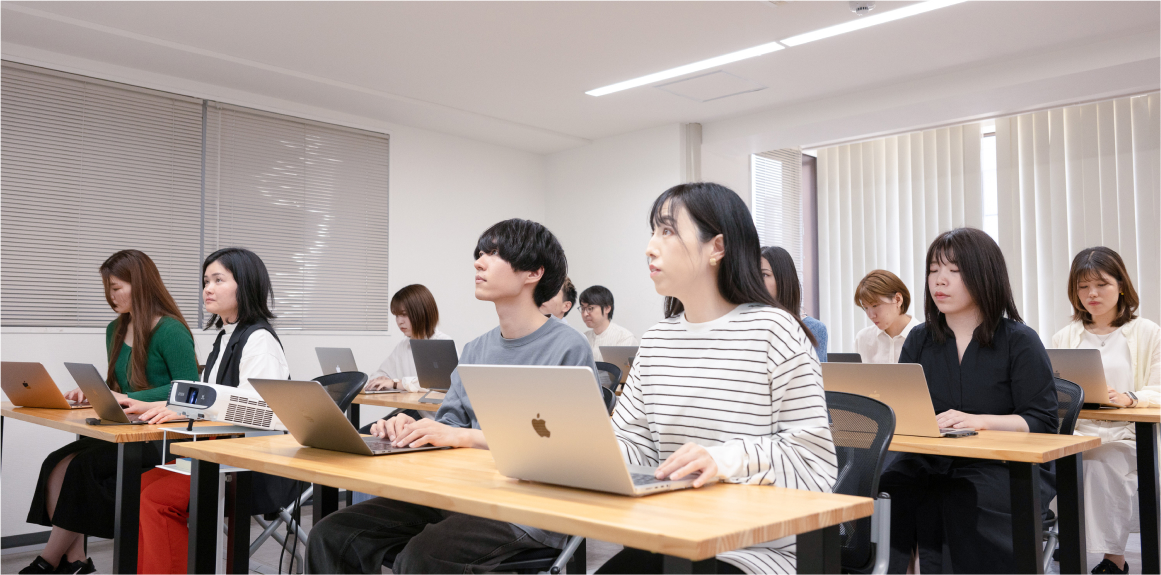 写真：教室でノートパソコンを使って学んでいる学生たちの様子